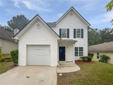Charming two-story home with attached garage and well-manicured front lawn and blue door at 7007 Setters Way, Lithonia, GA 30038
