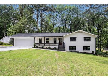 Charming renovated home with a freshly painted white brick exterior, black trim, and an inviting front porch at 106 Hickory Ave, Fayetteville, GA 30215