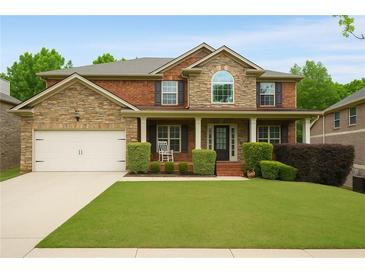Charming two-story home with brick and stone accents, manicured lawn, and a welcoming front porch at 4415 Saint Andrews Crest Dr, Cumming, GA 30040