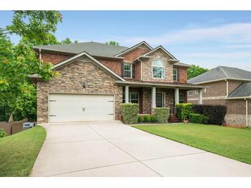 Beautiful two-story brick home with stone accents, manicured lawn, and a spacious driveway at 4415 Saint Andrews Crest Dr, Cumming, GA 30040
