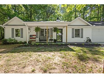 Charming single-story home featuring a cozy front porch and lush landscaping at 121 Danielle Ct, Villa Rica, GA 30180