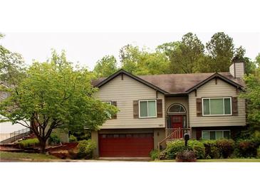 Charming two-story home featuring a red garage door, complemented by lush landscaping at 1425 Watercrest Cir, Lawrenceville, GA 30043
