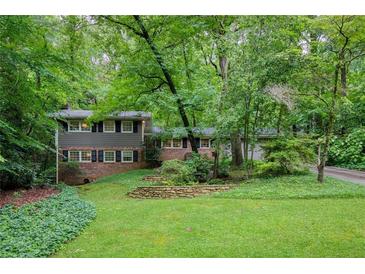 Charming two-story home featuring beautiful landscaping and mature trees at 220 N Springs Ct, Sandy Springs, GA 30328