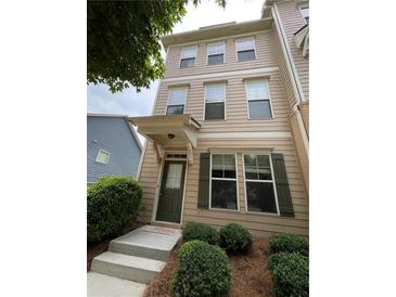 Charming townhouse featuring a welcoming entrance and well-maintained landscaping at 790 Village Field Ct, Suwanee, GA 30024