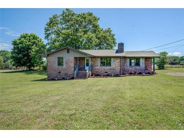 Charming brick home with a neatly manicured lawn and blooming flowerbeds, offering a warm and inviting curb appeal at 14721 Highway 36, Covington, GA 30014