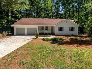 Charming single-story home with a manicured lawn and a three-car attached garage at 3766 Windy Hill Se Dr, Conyers, GA 30013
