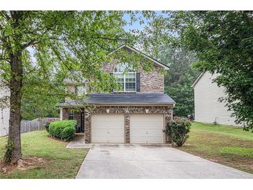 Charming two-story home with a two-car garage and well-maintained landscaping at 6664 Saint Jude Dr, Fairburn, GA 30213