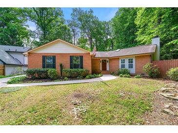 Traditional brick home featuring a lush, landscaped front yard and charming architectural details at 2991 Black Bear Se Dr, Marietta, GA 30067