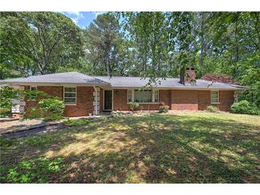 Charming brick home with a well-maintained lawn and mature trees providing shade at 3156 Pope Rd, Douglasville, GA 30135
