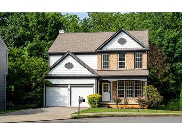 Charming two-story home with a well-maintained lawn, brick accents, and an attached two-car garage at 3260 Ridgefair Dr, Cumming, GA 30040