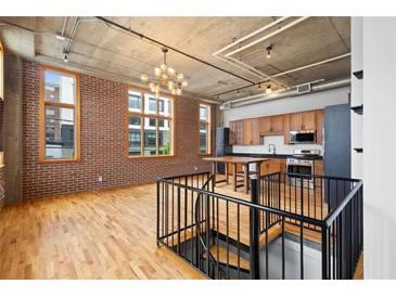 Bright living space with exposed brick, hardwood floors, and an open kitchen with stainless steel appliances at 660 Glen Iris Dr # 206 & 109, Atlanta, GA 30308