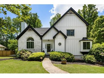 Charming home featuring a blend of brick and siding, a beautifully landscaped yard, and a welcoming walkway at 5600 Surrey Ct, Alpharetta, GA 30009