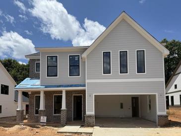 Two-story home featuring light gray siding, a two-car garage, brick accents, and black trimmed windows at 5627 Meadowstone Walk, Kennesaw, GA 30152