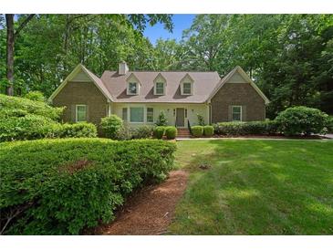 Charming brick home with manicured lawn and mature trees providing shade and curb appeal at 50 Stonington Pl, Marietta, GA 30068