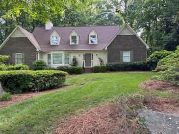 Charming brick home with manicured lawn and mature trees providing shade and curb appeal at 50 Stonington Pl, Marietta, GA 30068