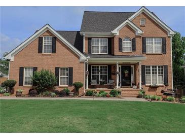 Charming brick two-story home with manicured lawn and inviting front porch at 1365 Juniper Springs Trl, Loganville, GA 30052