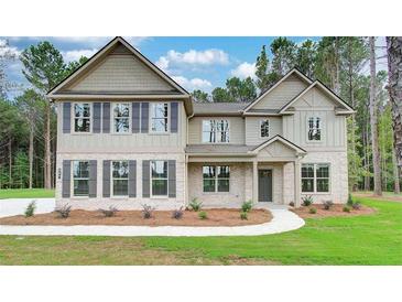 Charming two-story home featuring stone accents, a welcoming entryway, and a beautifully landscaped front yard at 145 Bre Dr, Fayetteville, GA 30215