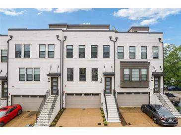 Modern townhomes boast a painted brick facade, individual garages, and inviting entry stairs at 830 Stone Ridge Ln, Atlanta, GA 30324
