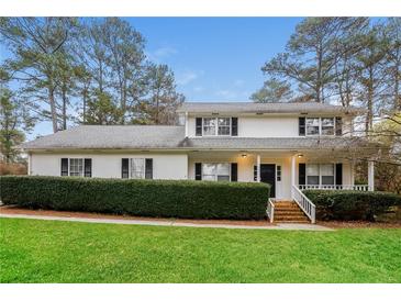 Charming home with a well-maintained lawn, mature trees, and welcoming front porch at 592 Cricket Hill Trl, Lawrenceville, GA 30044