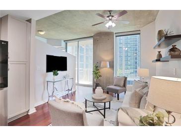 Bright living room with hardwood floors, modern furniture, and large windows with city views at 855 Peachtree Ne St # 1311, Atlanta, GA 30308