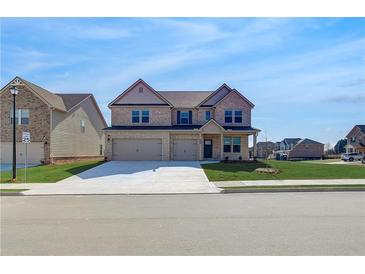 Attractive two-story brick home featuring a three-car garage, manicured lawn, and inviting curb appeal at 2447 Cadenza Cir, Dacula, GA 30019