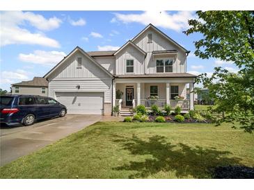 Charming two-story home with a well-manicured lawn and a welcoming front porch at 7095 Evening Dew Dr, Cumming, GA 30028