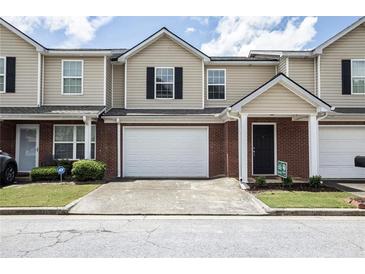 Charming townhome featuring brick accents, a single-car garage, and a welcoming front entrance at 132 Tara Commons Dr, Loganville, GA 30052