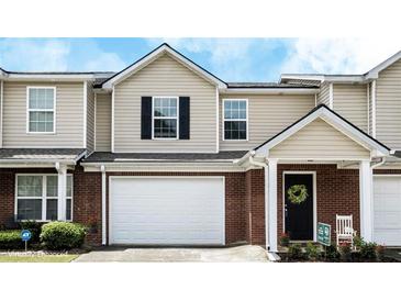Charming brick and siding townhome with an attached garage and well-maintained landscaping at 132 Tara Commons Dr, Loganville, GA 30052