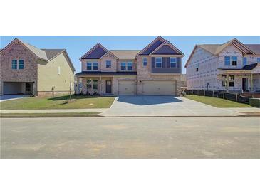 Charming two-story home with brick facade, a two-car garage, and a well-manicured front lawn at 2436 Cadenza Cir, Dacula, GA 30019