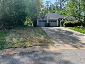 Charming single-story home featuring an attached two-car garage and long driveway at 410 Lima Ct, Woodstock, GA 30188