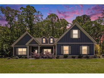 Charming craftsman home with a manicured lawn and lush landscaping, set against a picturesque twilight sky at 30 Deer Creek Ct, Moreland, GA 30259