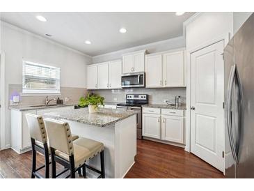 Bright kitchen with white cabinets, granite countertops, stainless appliances, and island seating at , Atlanta, GA 30318