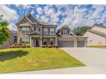 Beautiful two-story home with stone accents, three-car garage, and well-manicured lawn at 2910 Hampton Grove Trce, Dacula, GA 30019