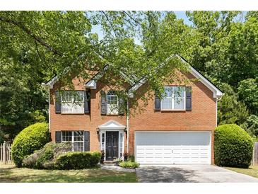 Charming two-story brick home featuring a well-maintained front yard and a two-car garage at 5404 Trumpet Vine Se Trl, Mableton, GA 30126
