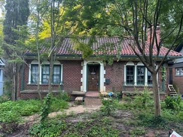 Charming brick home with a red tile roof and arched windows, surrounded by lush greenery at 1225 Cameron Ne Ct, Atlanta, GA 30306