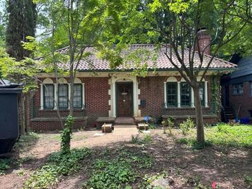 Charming brick home featuring a red tile roof, dark green trim, and a well-maintained front yard at 1225 Cameron Ne Ct, Atlanta, GA 30306