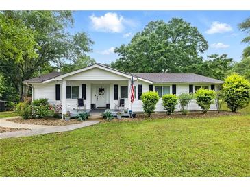 Charming single-story home featuring a well-manicured lawn and an inviting front porch at 1430 Mineral Springs Rd, Hoschton, GA 30548