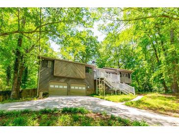A charming home features a front yard, two-car garage, and a stairway to the entrance at 2738 Westminister Nw Ln, Conyers, GA 30012