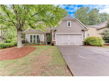 Charming single Gathering home featuring stone accents, an attached two car garage, and a well-manicured front yard at 4460 Delano Dr, Cumming, GA 30040