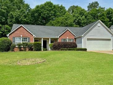 Charming brick home with well-maintained lawn and landscaping offering great curb appeal at 19 Windcrest Dr, Covington, GA 30016