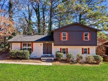 Charming home featuring a modern two-tone exterior with orange shutters, manicured lawn, and mature trees at 2814 Lloyd Rd, Decatur, GA 30034