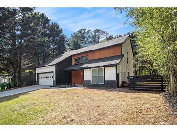 Modern two-story home with a dark roof, light wood accents, and an attached garage at 5346 Kelleys Mill Cir, Stone Mountain, GA 30088
