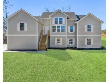 Inviting exterior elevation featuring a spacious front yard and a charming two-story design with a light gray exterior at 939 Whistler Ln, Canton, GA 30114