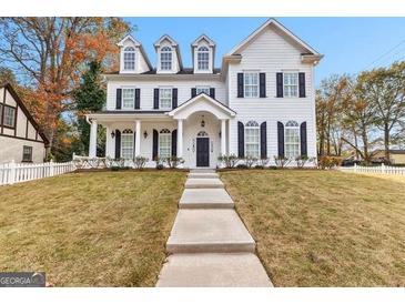 Elegant two-story white home featuring a well-manicured lawn and classic architectural details at 1898 Walker Ave, College Park, GA 30337