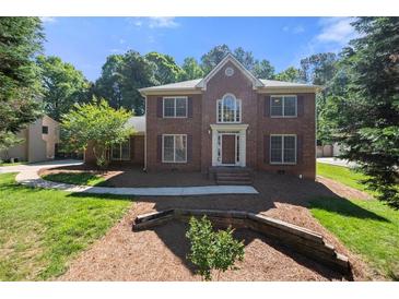 Charming two-story red brick home with symmetrical design, manicured lawn, and traditional architectural details at 227 Eton Ct, Mableton, GA 30126