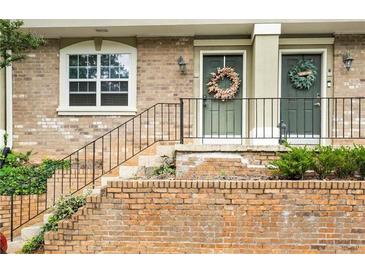 Charming brick townhouse with wreaths adorning the front doors and a lovely front entrance at 6900 Roswell Rd # 3N, Atlanta, GA 30328