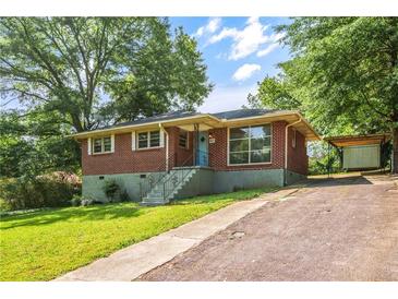 Charming brick home with a well-maintained lawn and a covered carport at 765 Shellnut Dr, Forest Park, GA 30297