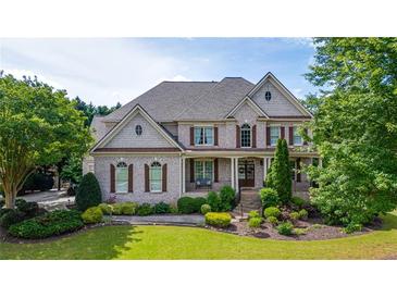 Charming two-story home with a manicured front lawn and mature trees, offering great curb appeal at 100 Braxton Way, Roswell, GA 30075