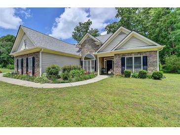 Charming single-Gathering home with stone accents, a landscaped front yard, and a well-maintained lawn at 1815 Sharon Rd, Cumming, GA 30041