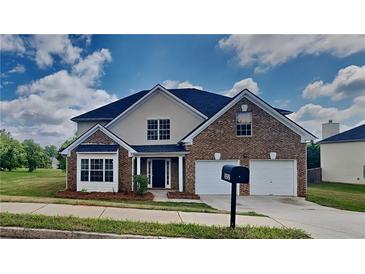 Charming two-story brick home with a well-manicured lawn, two-car garage, and attractive landscaping at 5052 Hickory Cir, Ellenwood, GA 30294